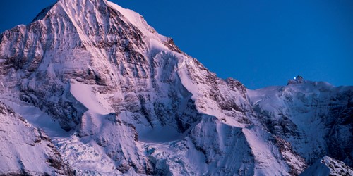 Monch at sunset tinged pink in Grindelwald ski resort, Switzerland